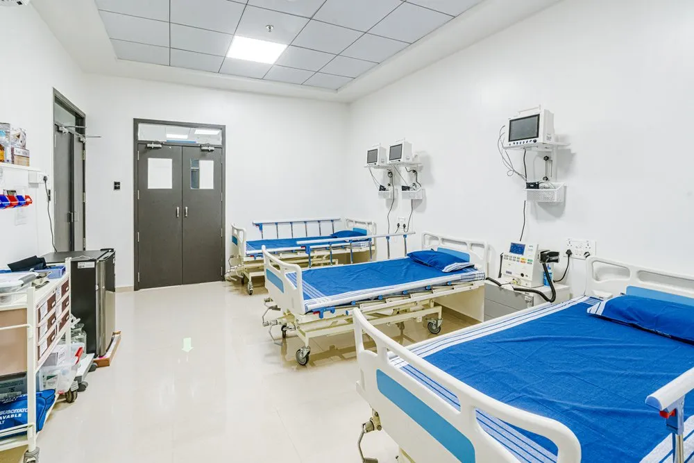 Medical monitoring room with hospital beds, patient monitors, and emergency equipment